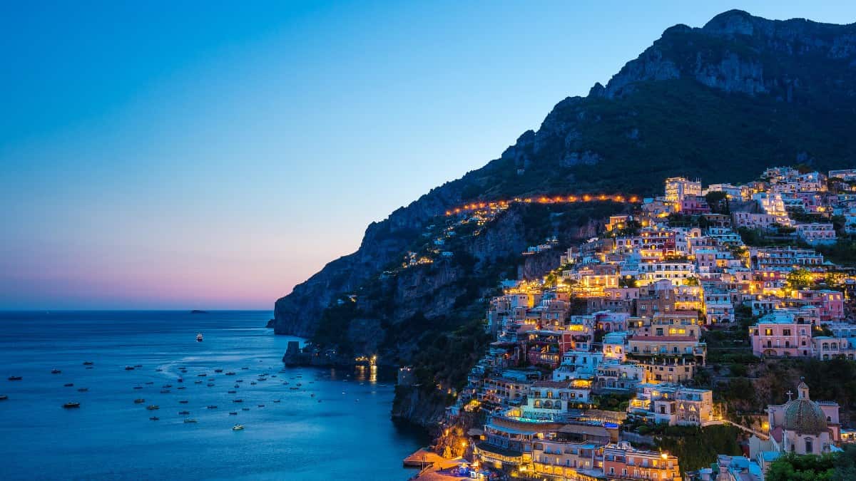 A vibrant image of a Sunset view of colorful cliffside villas in Positano, Amalfi Coast.